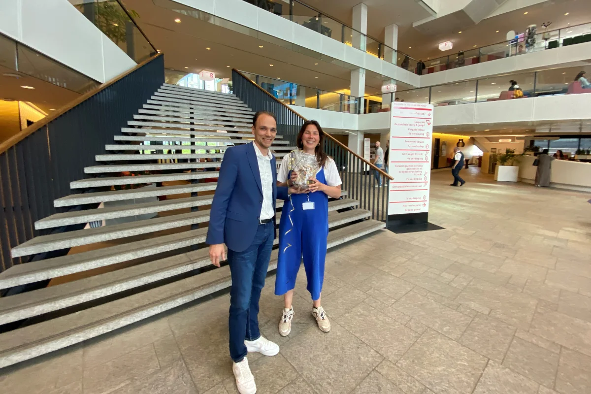 Janne Verberne van de gemeente Utrecht neemt de prijs van de puzzelactie tijdens het NVVB jaarcongres in ontvangst van Jeroen van Tamelen, sales manager bij Lamsonair